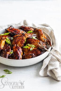 Kippenboutjes uit de airfryer. Bord met stapel kippenboutjes