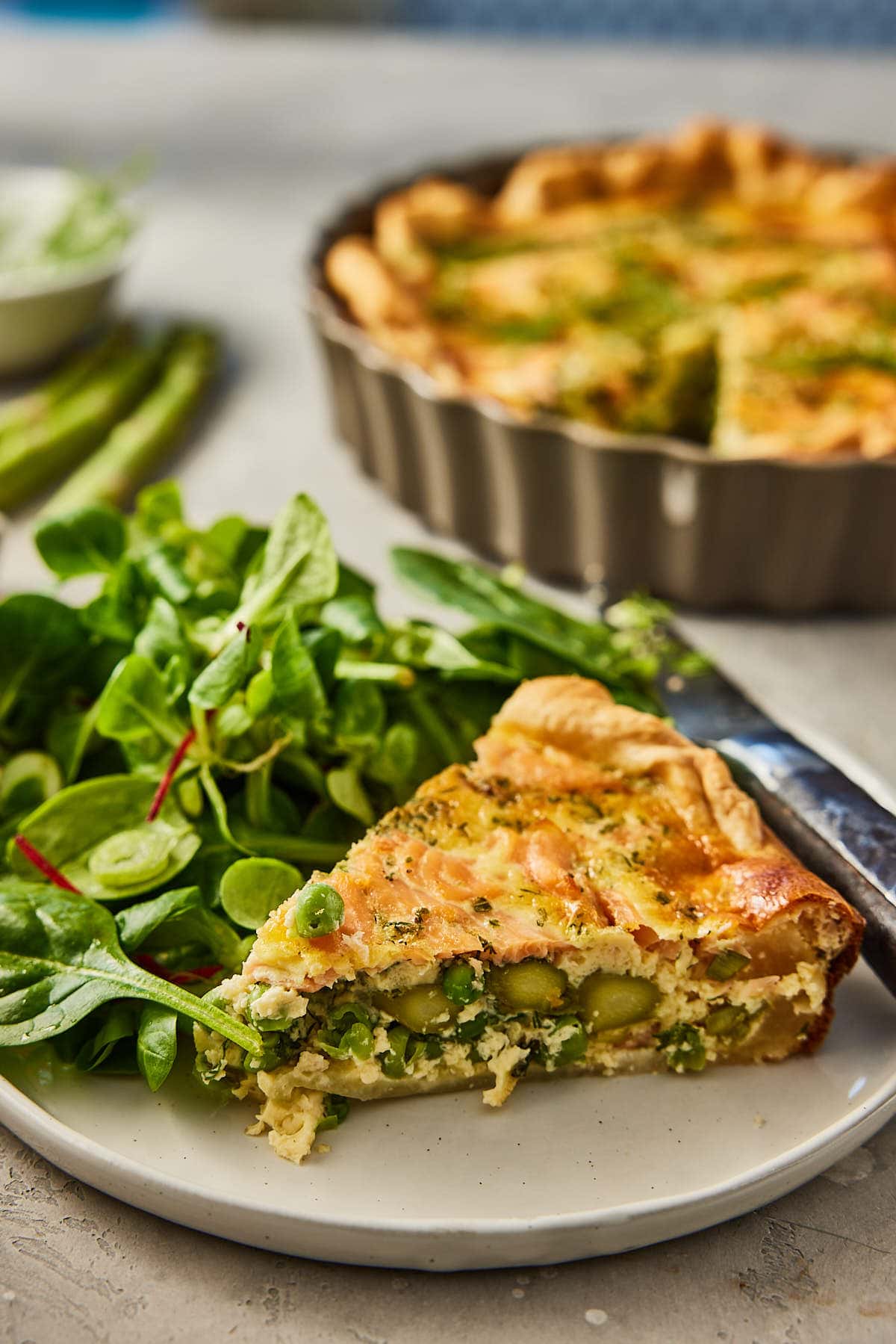 Stuk gesneden quiche met asperges en zalm