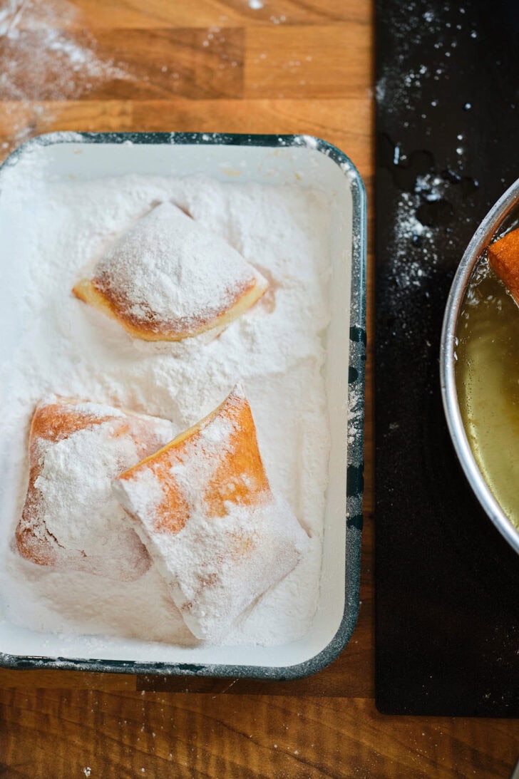 New Orleans beignets door het poedersuiker rollen